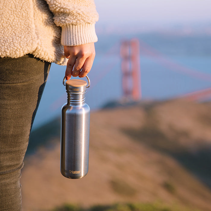 27oz-reflect-with-bamboo-cap-s7 K27SSLRF-BS-BAMBOO_reflect_bottle_bridge_lifestyle.jpg